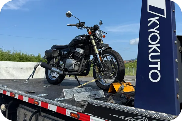 積載車に故障したバイクを載せてレッカー搬送中の様子