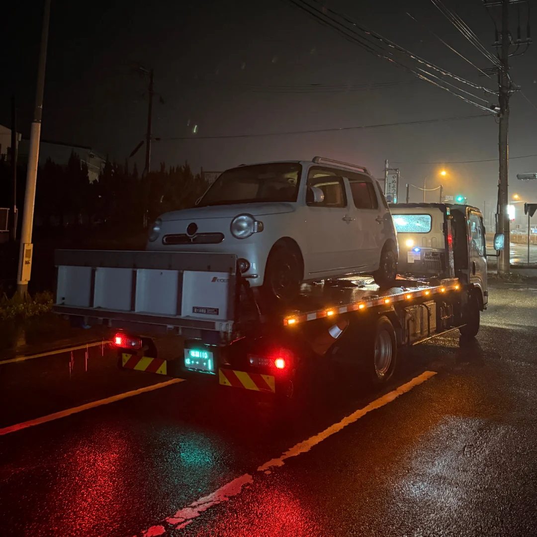 夜間の雨の中で事故車をレッカー搬送する様子(福岡市博多区)