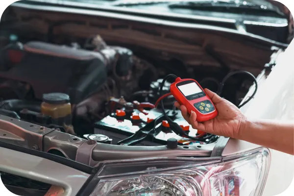 バッテリー上がりの車両を電圧計を使いチェックしている場面